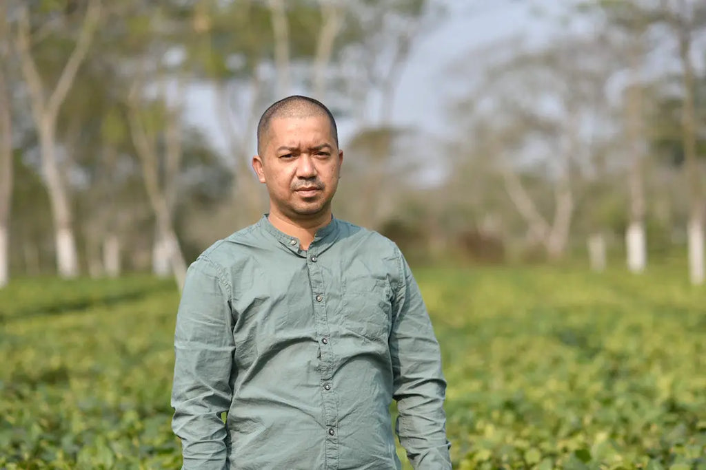 assames farmer nayanjyoti posing in front of his organic tea garden in assam india